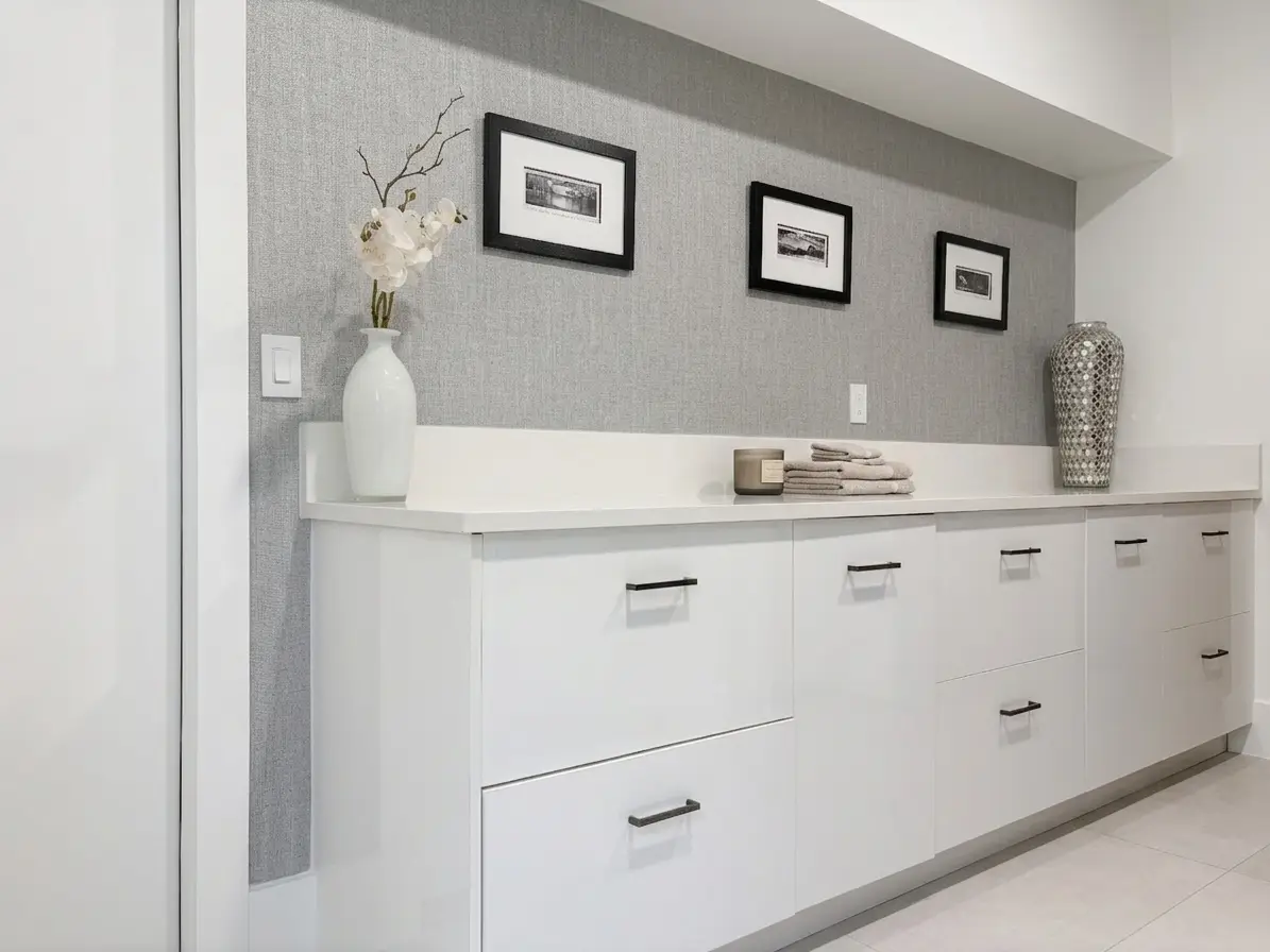 Laundry room with dual stacked washer and dryer, built-in cabinetry, and spacious countertops